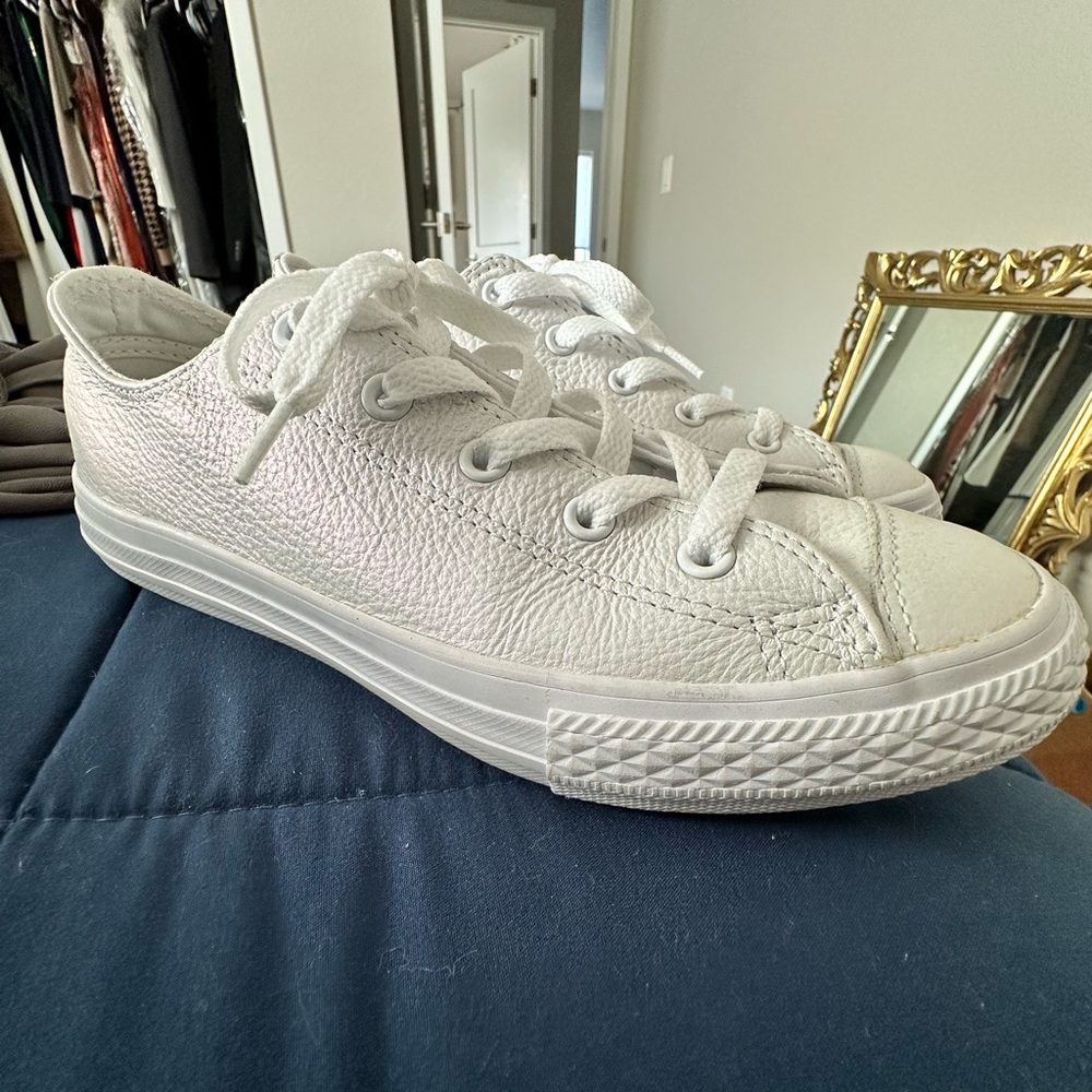 White pearl metallic Converse All Star shoes.